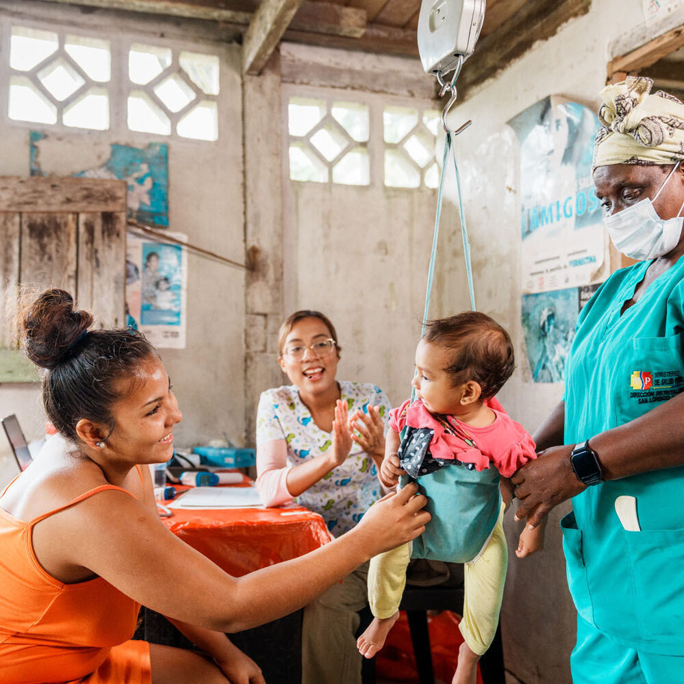 A cocoa farmer's baby is being weighed by the doctor